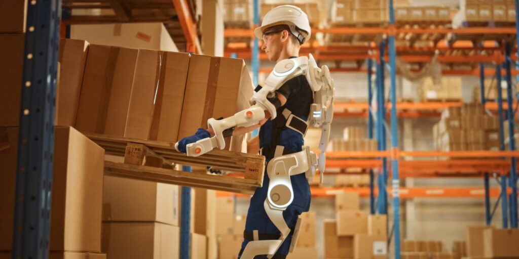 warehouse worker wearing exoskeleton to help lift boxes